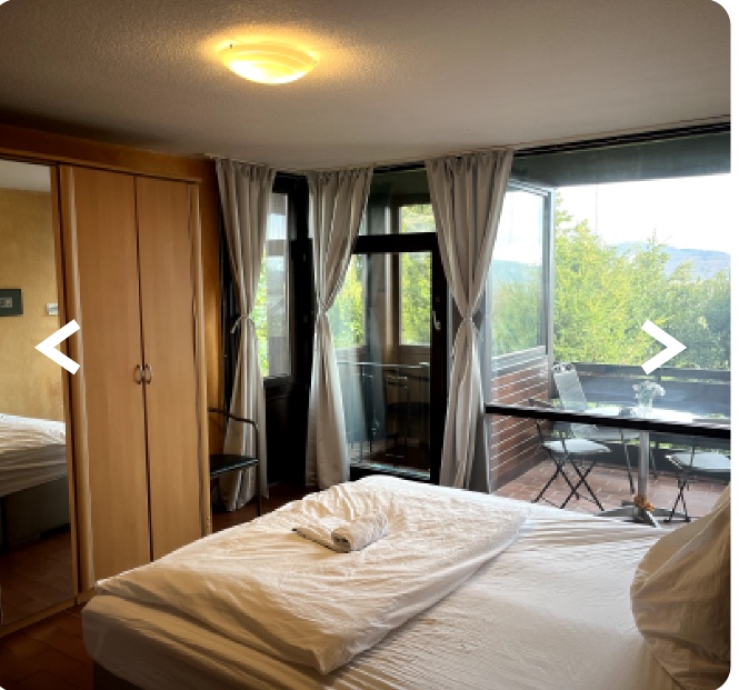 Schlafzimmer mit Boxspringbett und Zugang zum Balkon
